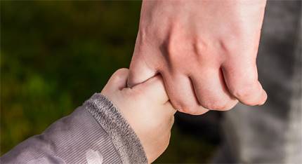 En barn hand i en vuxens hand