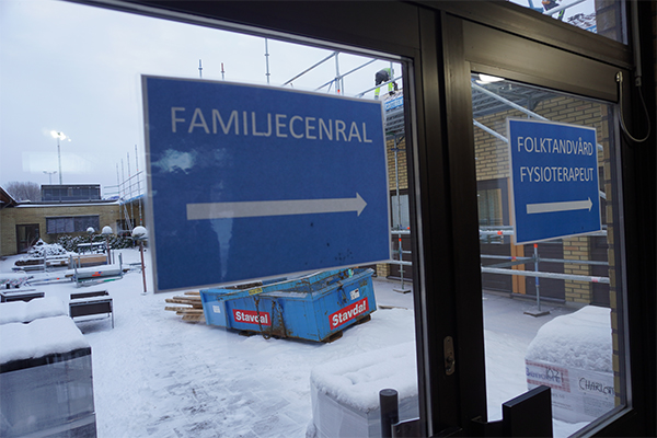 Arbetare på taket bakom skyltar till verksamheter