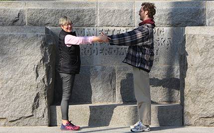 Birgitta Lind och Felix Tärnbrant håller varandras händer framför Fredsmonumentet