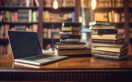 Bibliotek med böcker och dator på ett skrivbord