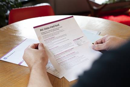 En person håller ett brev med information om budröstning