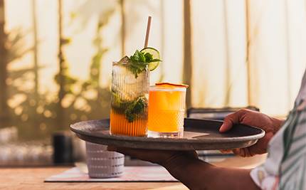 Drinkglas på bricka i kvällsljus