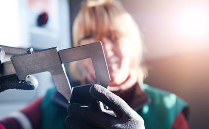 Kvinna håller i metallverktyg