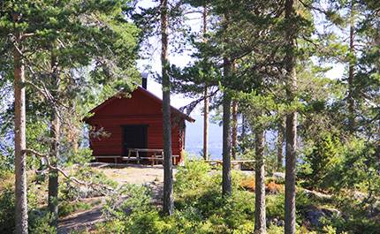 Röd stuga bland tallar på Valfjällstoppen