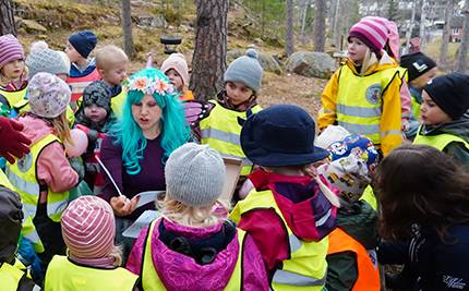 Sagofen med barn från förskolan Blåsippan runt sig, i skogen