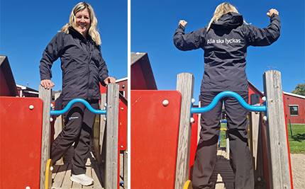 Förskollärare i klätterställning visar upp nya mörkblå arbetskläder. På jackans rygg står det: Alla ska lyckas