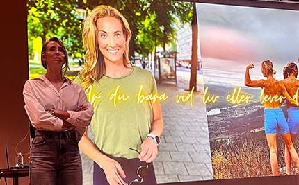 Ida Kjos framför presentation med bilder av henne och hennes tvillingsyster som posar med texten: Är du bara vid liv eller lever du?