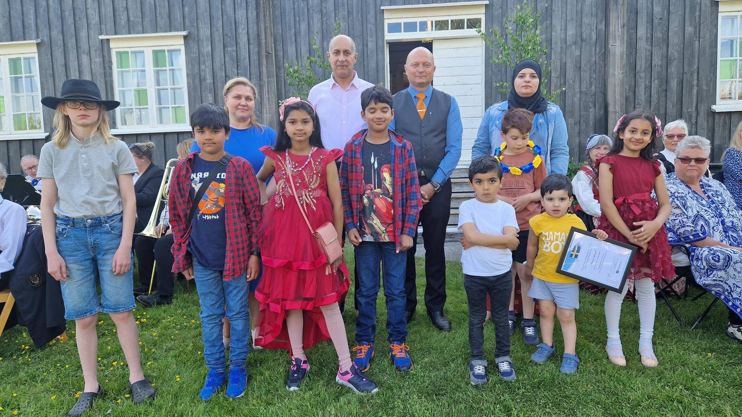 Gruppfoto av nya svenska medborgare på Eda hembygdsgård 6 juni 2023