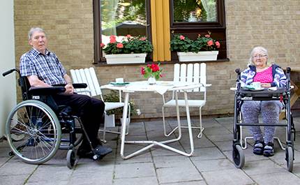Två vårdtagare i rullstol fikar utomhus på Älvgården