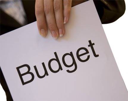 Hand håller skylt med text budget