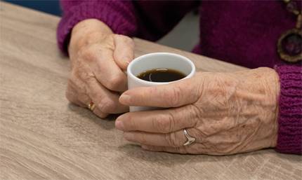 Händer som håller i en kaffekopp