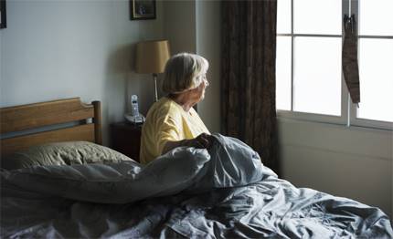Kvinna som sitter på sängkanten