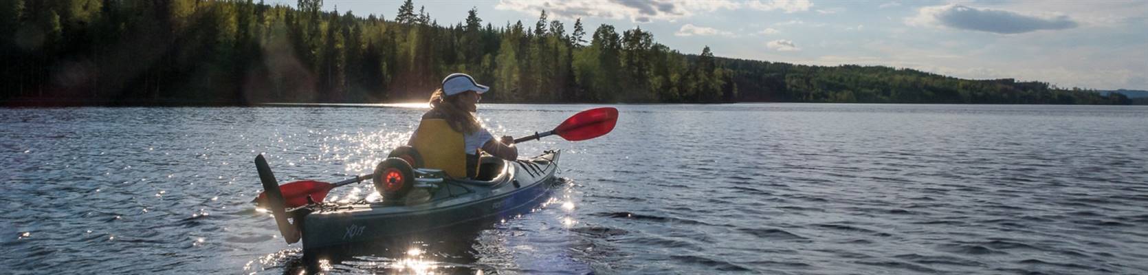 En kvinna paddlar kajak på en sjö
