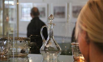 Kvinna som tittar på utställning på Eda glasbruks museum